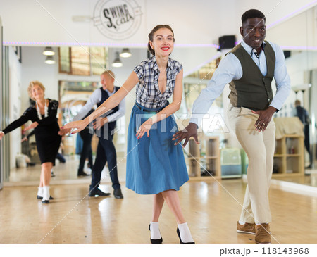 Woman with african man practising charleston dancing 118143968