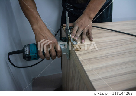 worker using a gouge on an old wooden cabinet worker using a gouge on an old wooden cabinet 118144268