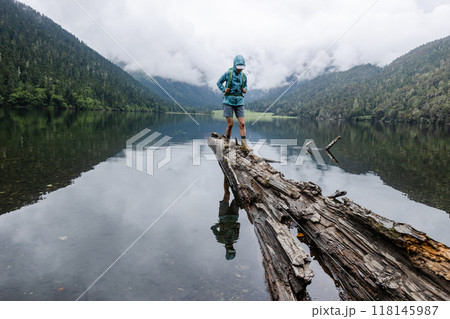 Hiking woman on a one plank bridge in high altitude mountains 118145987