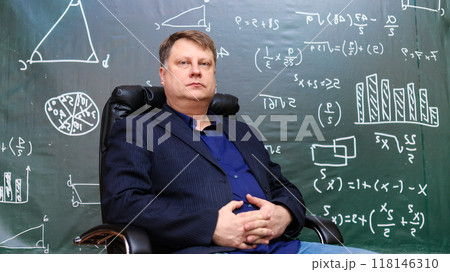 Portrait of a male teacher at a university sitting in a comfortable leather chair at the department 118146310