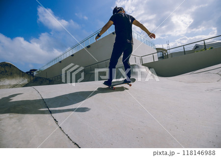 Skateboarder skateboarding at skatepark in city 118146988