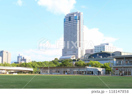 ひろしまスタジアムパーク HiroPa（ヒロパ）の芝生広場から見る県立体育館とリーガロイヤルホテル 118147858