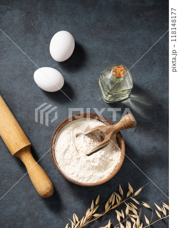 Oatmeal in a wooden bowl with eggs, rolling pin and oli on a dark background. Oatmeal in a wooden bowl with eggs, rolling pin and oli on a dark background. 118148177