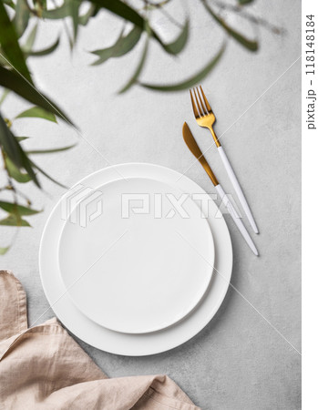 Festive table setting with empty white plate and  cutlery for holiday with eucalyptus branches 118148184