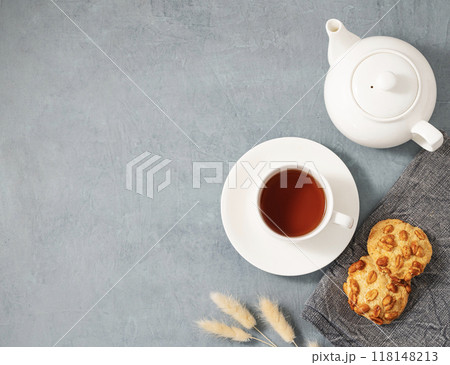 A cup of fragrant tea with homemade cookies and a white teapot on a blue background. 118148213