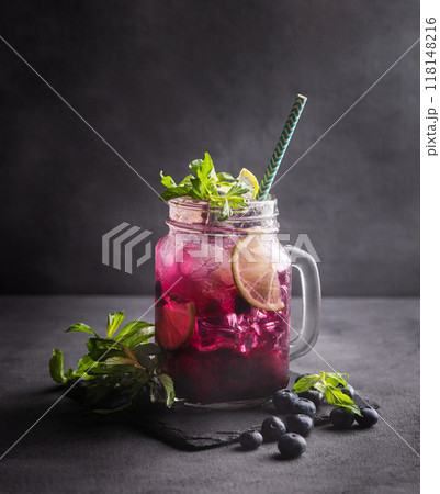 Refreshing blueberry mojito or lemonade with lime, mint and ice on a dark background. 118148216