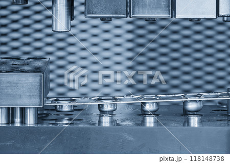 The stamping operation of metal drawing process on the progressive die in the light blue scene. The stamping operation of metal drawing process on the progressive die in the light blue scene. 118148738