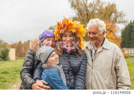 Autumn family portrait. Senior man and woman, mid adult woman and child girl outdoor Autumn family portrait. Senior man and woman, mid adult woman and child girl outdoor 118149008