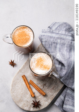 Two glass mugs with hot chocolate and milk foam on a light marble board on a gray background Two glass mugs with hot chocolate and milk foam on a light marble board on a gray background 118149190