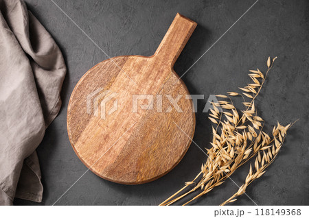 Empty wooden board on dark texture background with dry branch and kitchen towel.  118149368