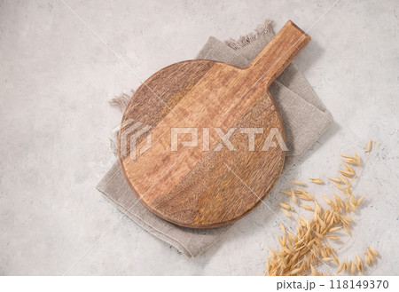 Empty wooden board on light texture background with dry branch and kitchen towel.  118149370