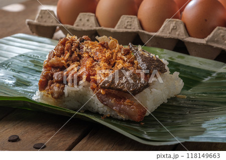 Sticky rice with fried pork and pork offal wrapped in natural banana leaves and the egg tray is a home essential idea. Sticky rice with fried pork and pork offal wrapped in natural banana leaves and the egg tray is a home essential idea. 118149663