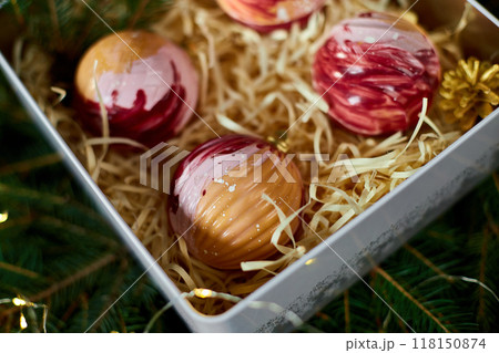Delightful Assorted Dessert Spheres Displayed in a Gift Box Surrounded by Festive Greenery and Decorative Accents Delightful Assorted Dessert Spheres Displayed in a Gift Box Surrounded by Festive Greenery and Decorative Accents 118150874