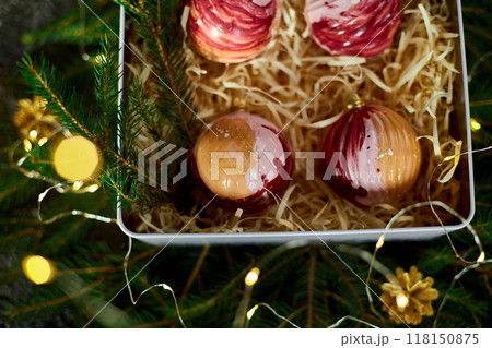 Delightful Assorted Dessert Spheres Displayed in a Gift Box Surrounded by Festive Greenery and Decorative Accents 118150875