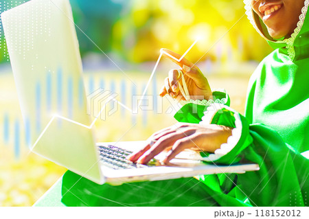 A woman is sitting on the ground and using a laptop 118152012