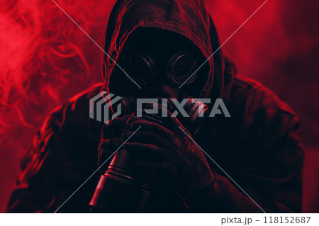 A person wearing a gas mask with a red light, in a horror-style setting with a dark background. 118152687