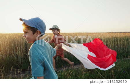 Polish little cute boys running with Poland national flag. Patriotism. Red and white colors, 11 November - Independence Day. Friends, brothers, happy future. 118152950