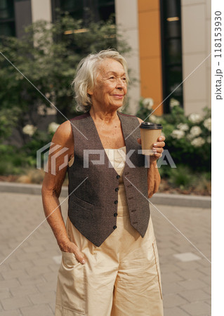 A Stylish Elderly Woman Enjoys Sipping Her Coffee Relaxingly Outdoors in the Sunlight 118153930