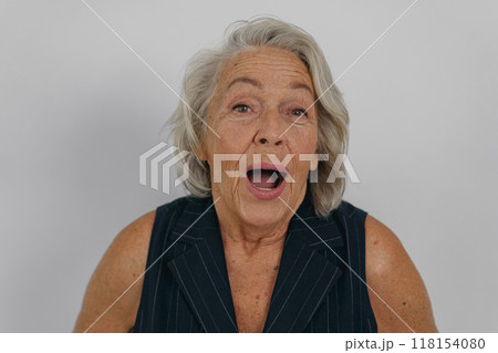 A Surprised Senior Woman Joyfully Expressing Her Delight and Happiness in a Candid Moment 118154080
