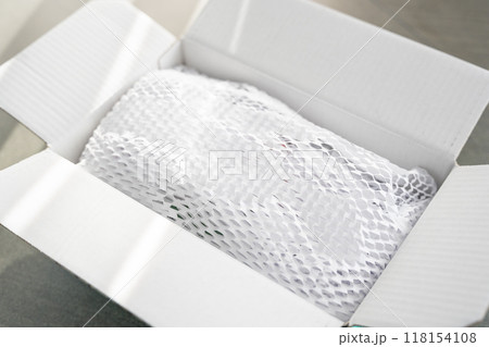 Corrugated white paper for safe transportation, in which the goods brought by the courier delivery service are wrapped, environmental packaging concept Corrugated white paper for safe transportation, in which the goods brought by the courier delivery service are wrapped, environmental packaging concept 118154108