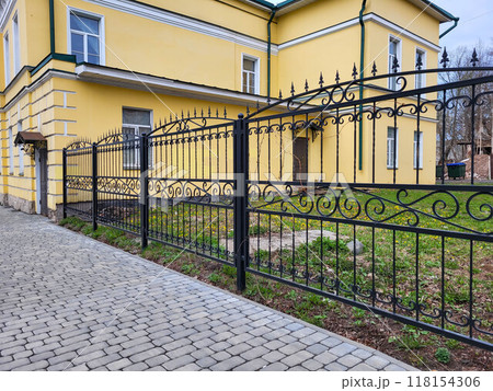 Black beautiful new cast iron openwork fence on a cloudy autumn day Black beautiful new cast iron openwork fence on a cloudy autumn day 118154306