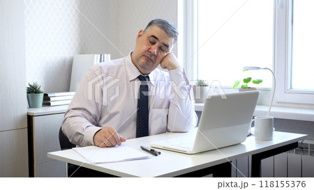 Man Napping at Office Desk with Head Resting on Hand 118155376