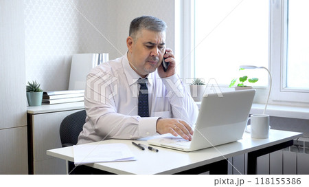 Man in Office Angry While Talking on Phone 118155386