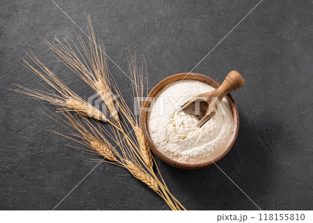 Wheat flour and dry branch on a dark background. Organic baking ingredients. Wheat flour and dry branch on a dark background. Organic baking ingredients. 118155810