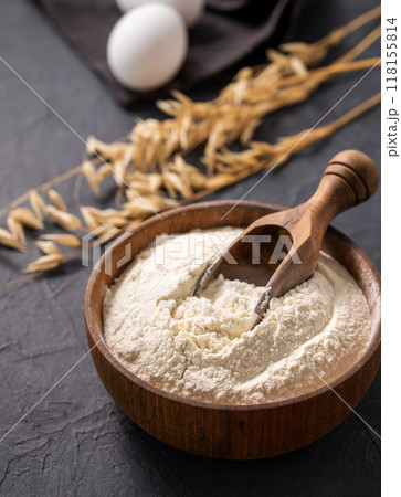 Organic baking ingredients. Oatmeal and eggs  on a dark  background close up.  118155814
