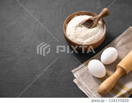 Organic baking ingredients. Flour, eggs and rolling pin on a dark background. Organic baking ingredients. Flour, eggs and rolling pin on a dark background. 118155820