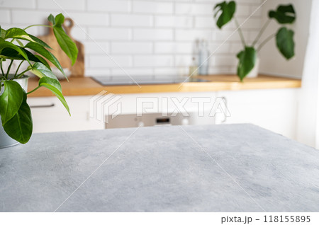 Wooden blue table top with flower pot against blurred white kitchen with cutting board Wooden blue table top with flower pot against blurred white kitchen with cutting board 118155895