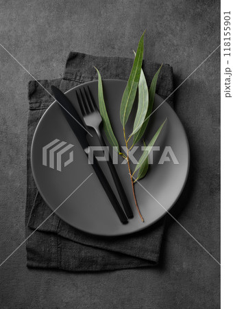 Festive table setting with empty gray plate and black cutlery for holiday with eucalyptus 118155901