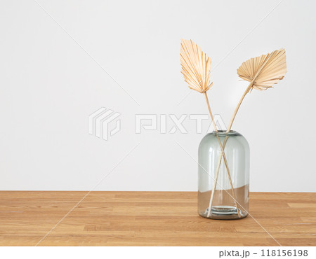 Stylish modern dry palm leaves in glass vase on a wooden background  in Scandinavian style. 118156198