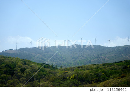 山の上に立つ自然エネルギーの風力発電の風車と青空 118156462