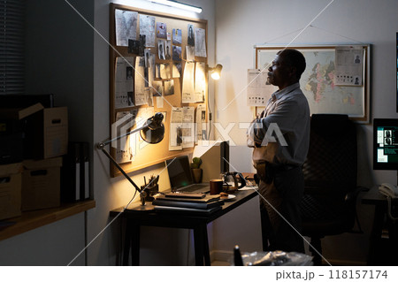 Studying Evidence in Dimly Lit Detective Office Studying Evidence in Dimly Lit Detective Office 118157174