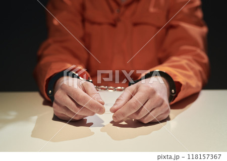 Handcuffed Individual Wearing Orange Jumpsuit in Custody 118157367