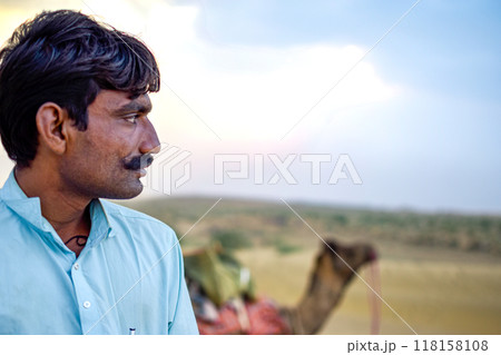 Rajasthan Male model with mustache, desert background and camel looking horizon Rajasthan Male model with mustache, desert background and camel looking horizon 118158108
