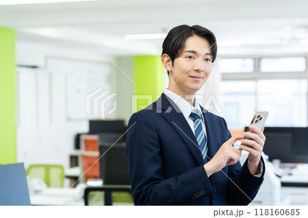 オフィスでスマホを持つビジネスマン 118160685