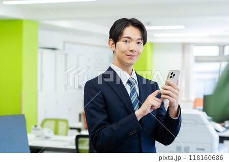 オフィスでスマホを持つビジネスマン 118160686