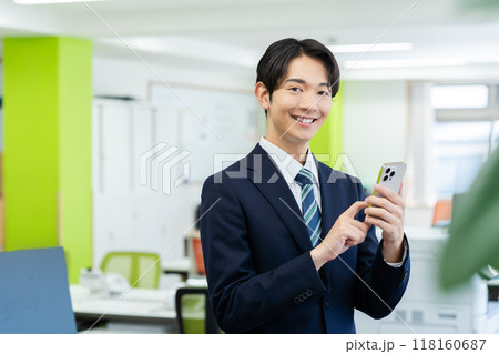 オフィスでスマホを持つビジネスマン 118160687