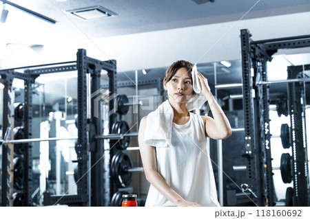 スポーツジムで汗を拭く若い女性 118160692