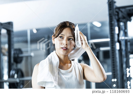 スポーツジムで汗を拭く若い女性 118160693