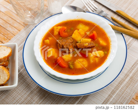 Image of appetizing tender stewed veal with sauce with potatoes and vegetables. Spanish appetizer - patatas estofadas con carne 118162582