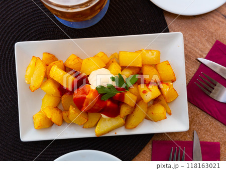 Spanish dish Patatas bravas with hot sauce 118163021