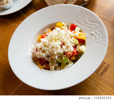 Shopska salad - dish of Balkan cuisine. Cucumbers, tomatoes, bell peppers and brynza  118163154