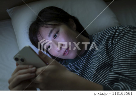 ベッドでスマホを見る女性 ベッドでスマホを見る女性 118163561