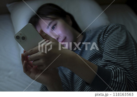 ベッドでスマホを見る女性 ベッドでスマホを見る女性 118163563