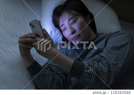 ベッドでスマホを見る女性 118163568