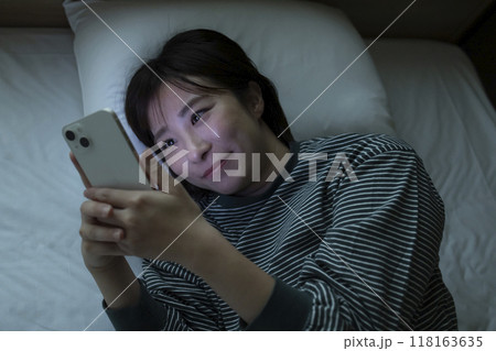 ベッドでスマホを見る女性 118163635