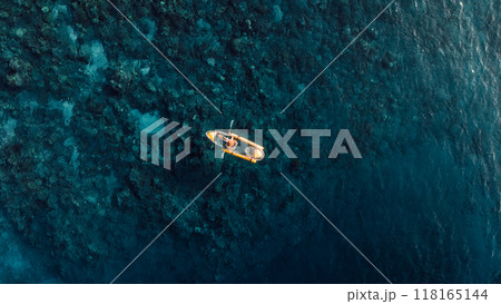 Woman kayaking in sea on transparent kayak. Drone view Woman kayaking in sea on transparent kayak. Drone view 118165144